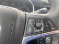 Close-up of the steering wheel controls in a 2018 Buick Encore featuring buttons for phone, audio, and cruise control settings