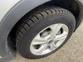 Close-up of a silver 2014 Ford Escape front tire with a multi-spoke alloy wheel and all-season tire tread pattern