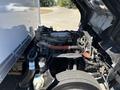 A 2022 Isuzu NRR truck with its hood open showcasing the engine compartment featuring various components including hoses and an air filter