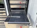 A close-up of an empty metal drawer with a handle in a storage compartment of a 2017 Ford F-550