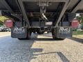 A 2018 Ford F-750 viewed from below showing the rear axle and dual tires with mud flaps featuring a motor group logo