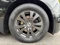 Close-up of a black alloy wheel with a Honda emblem featuring ten spokes set on a tire with visible tread pattern