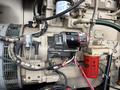 A Katolight SED60FPJ4 generator featuring a starter motor and fuel filter with various wires and hoses connected to the engine components