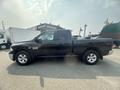 A black 2015 RAM 1500 truck is shown from the side with a crew cab and chrome accents on the wheels and grille