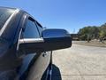 A close-up view of the side mirror of a black 2015 RAM 1500 truck showing its sleek design and reflective surface