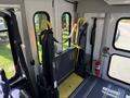 Interior view of a 2015 Ford Econoline showing a foldable wheelchair ramp at the entrance with a yellow platform and black side supports