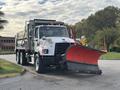 A 2013 Freightliner 114SD truck equipped with a large red snow plow attached to the front and a dump bed at the rear