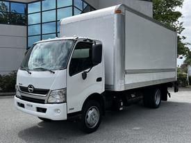 A 2018 Hino 195 truck with a white cab and a large silver cargo box in the back