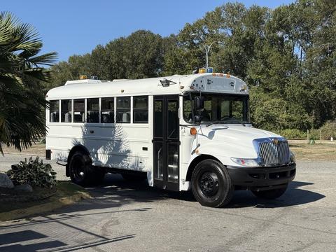 A white 2013 International CE300 school bus with black wheels and multiple windows on the sides