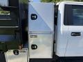 A 2019 Ford F-550 with a diamond plate toolbox attached to the side featuring two latch locks
