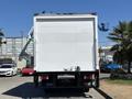 A 2022 Isuzu NQR truck facing towards the viewer with a plain white cargo box and a tow hitch visible at the bottom