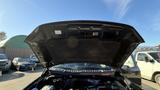 A black 2016 Ford F-150 with the hood opened revealing the engine compartment