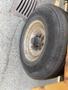 Close-up of a tire from a 2010 Vermeer Corporation BC1200XL showing wear with a partly rusty rim and visible tread patterns