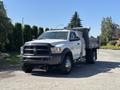 A 2016 RAM 5500 truck with a flatbed and tool storage compartments parked on a paved surface