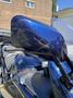 A blue 2016 Yamaha FJR1300AE motorcycle with a damaged left mirror reflecting light and showing scratches on its surface