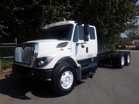 A white 2009 International 7400 truck with a prominent front grille, large wheels, and a spacious cab is parked with its side facing the viewer