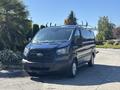 A blue 2016 Ford Transit 150 van with a ladder rack on top parked in a sunny area