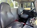 Interior of a 2013 International 7500 featuring two gray seats with safety belts and a dashboard visible in the background