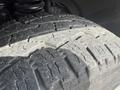 Close-up of a worn tire tread on a 2011 Ford F-350 SD showing visible grooves and dirt accumulation