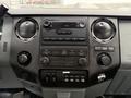 Dashboard of a 2011 Ford F-250 SD featuring audio controls climate controls and various switches