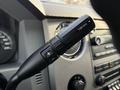A close-up of the gear shift lever of a 2015 Ford F-550 featuring a tow/haul control button with plus and minus indicators