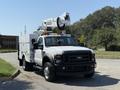 A white 2008 Ford F-550 with an elevated bucket and a utility bed designed for maintenance work