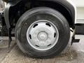 Close-up of a silver hubcap and tire on a 2009 UD Trucks UD 3300 with prominent tread visible on the tire