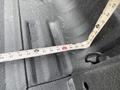 A measuring tape is laid across the bed of a 2011 Ford F-250 SD showing a measurement of 64 inches