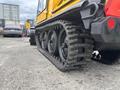 A 2004 Bombardier SW48 with a rubber track system and large wheels visible in the foreground
