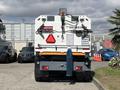 Rear view of a 2012 Autocar Xpert truck featuring warning signs, large reflective triangles, and a blue exhaust pipe