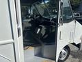 A 2012 Ford E-450 with an open door showing the driver's seat dashboard and interior features including controls and seating