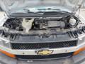 Open hood of a 2011 Chevrolet Express displaying the engine compartment with various components including the engine and fluid reservoirs