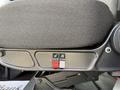 Close-up of a fabric seat with two control buttons for adjustments positioned on the side panel