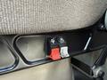 Close-up of two seat adjustment levers on a Kenworth T370 one red lever and one black lever for moving the seat forward and backward
