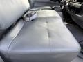 A gray vinyl bench seat inside a 2014 Hino 195 truck with visible texture and a seatbelt secured on the seat