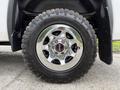 Close-up of a chrome wheel rim with the GMC logo on a tire labeled Goodyear Wrangler all-terrain tire on a 2016 GMC Sierra 1500
