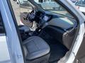 Interior of a 2018 Hyundai Santa Fe featuring beige leather seats a steering wheel and a dashboard with a touchscreen display and various controls