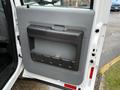 A close-up view of the door panel of a 2016 Ford F-550 Super Duty featuring a large storage compartment with a molded design and a handle on the top