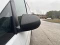A close-up of the side mirror of a 2021 Mercedes-Benz Metris with raindrops on the surface