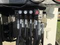 A close-up view of a hydraulic control panel with several levers and buttons labeled for functions on a 2011 International 7500 truck