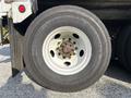 A close-up view of a white wheel with a Continental tire showing rusted bolts and a heavy tread pattern on a 2011 Autocar Xpeditor