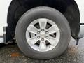 A silver aluminum alloy wheel of a 2024 Chevrolet Silverado 1500 with a black tire mounted on it