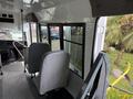 Interior of a 2013 Chevrolet Express showing two gray seats and a view of large windows on the side of the vehicle
