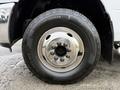 Close-up of a wheel from a 2013 RAM 3500 showing a chrome hubcap and a heavy-duty tire with rugged tread pattern