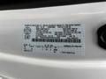 A white 2023 Ford F-450 Super Duty displaying a manufacturer’s label with vehicle specifications and identification details
