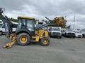 A 2012 John Deere 310SJ backhoe loader with a yellow exterior and black cabin positioned with a raised front bucket and extended rear excavator arm