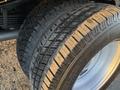 Close-up of two closely positioned tires with a rugged tread pattern mounted on a white rim intended for a 2015 GMC Savana