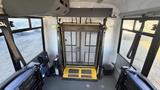 Interior view of a 2021 Ford Transit with a lowered wheelchair ramp and seating for passengers visible