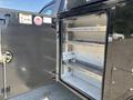 The image shows the open door of a 2022 Ford F-350 SD revealing a spacious storage compartment with metal shelves inside
