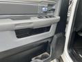 Interior door panel of a 2015 RAM 2500 featuring controls for windows and locks with a RAM logo and various textured finishes